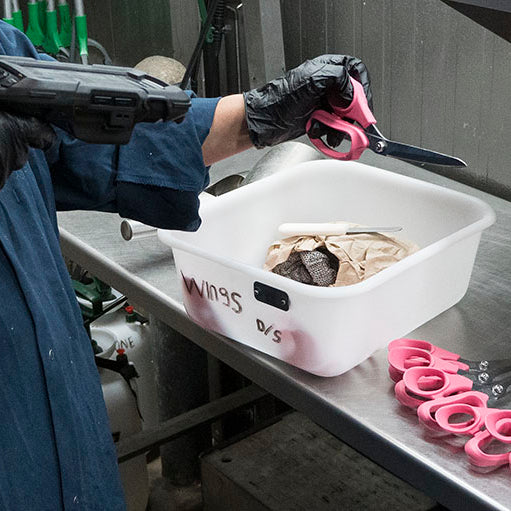 a worker scans poultry processing shears on a production line before use