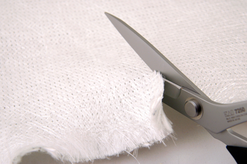 A worker using Wolff shears to cut a piece of composite fiberglass.