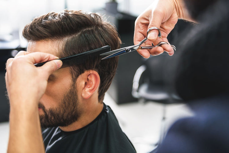 Barber cutting a customer's hair with professional beauty scissors