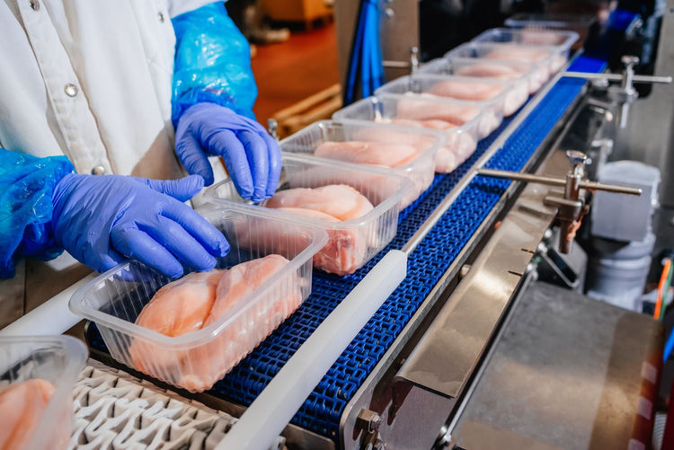 Freshly sliced meat moving on a conveyor in a food processing facility